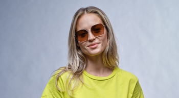 Das Bild zeigt eine blonde, junge Frau mit einer Metallsonnenbrille.